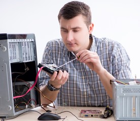 Young technician repairing computer in workshop