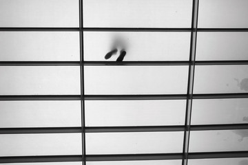 Black and white conceptual art photograph with feet of people who shine through a translucent...