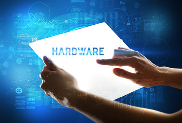 Hand holdig futuristic tablet with HARDWARE inscription, new technology concept