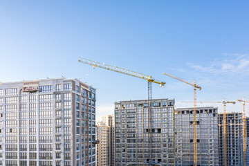 Fototapeta na wymiar construction site with high-rise buildings and cranes on blue sky background. new residential area. aerial view