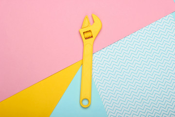 Toy wrench on a colored pastel background. Top view. Minimalism