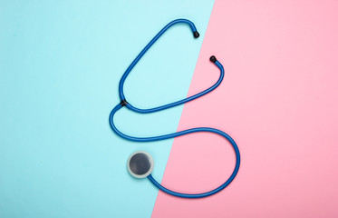 Stethoscope on a blue-pink pastel background. Top view