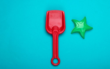 Children's shovel and toy star for a sandbox or beach on blue background. Top view