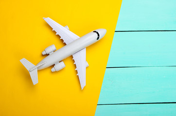 Airplane on a yellow, blue wooden background. Top view. Vacation, travel concept
