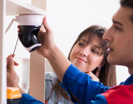 Client getting securty camera installed at home by contractor