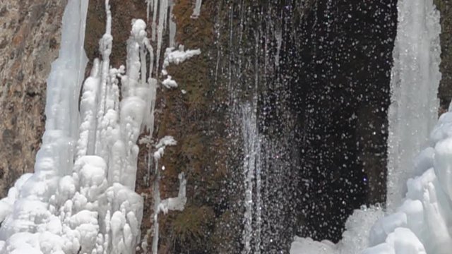 The entrance to the cave with ice columns that melt in the spring and drops everywhere. Super slow motion 1000 fps