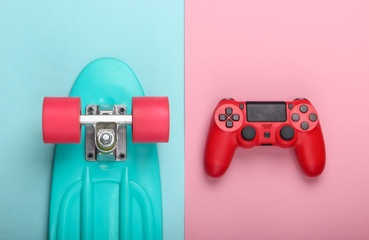 Red Gamepad with cruiser board on pink blue pastel background. Childhood concept, summer fun, entertainment. Top view. Flat lay