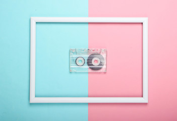 Audio cassette on pink blue pastel background with white frame. Studio shot. Creative retro flat lay. Top view. Minimalism. 80s
