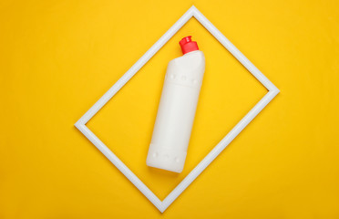 Bottle of detergent on yellow background with  white frame. Top view. Minimalism