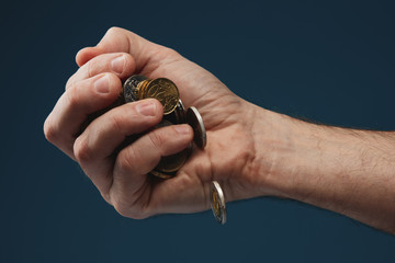 The concept of falling revenue/income. Various coins from around the world held in hand. Coins...