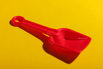 Children's toy shovel for a sandbox on a yellow background