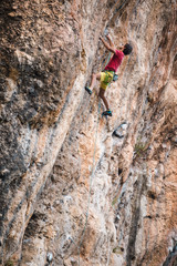 ?limber overcomes a difficult climbing route on a natural terrain.