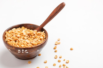 Dried chickpea lentils in wooden bowl and spoon on white background , Split Chickpea Also Know as Chana Dal