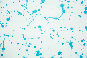 Abstract splatter of blue paint on a white background