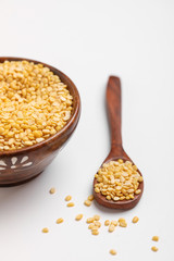 yellow moong mung dal lentil pulse bean in wooden and spoon bowl on white background