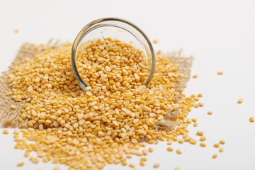 yellow moong mung dal lentil pulse bean in glass bowl on white background
