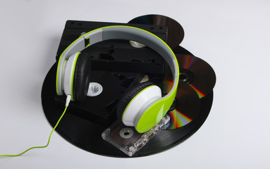 Retro media. Stereo headphones, video cassettes, vinyl records, audio cassette, cd discs on a white...