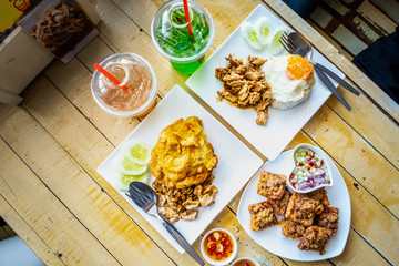 Table full of Chinese and Thai food with glass of drink for travellers.