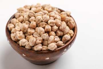 Uncooked dried chickpeas in wooden bowl and spoon