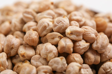 Uncooked dried chickpeas in wooden bowl