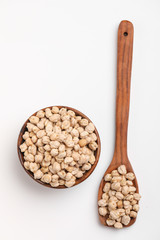 Uncooked dried chickpeas in wooden bowl and spoon