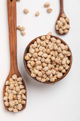 Uncooked dried chickpeas in wooden bowl and spoon