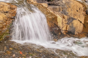 Obraz premium view of silky waterfall flowing on arch rock background, Pha Suea Waterfall, Mae Hong Son Province, northern of Thailand.