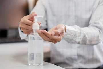 Man hands using wash hand alcohol gel or sanitizer bottle dispenser, against Novel coronavirus or Corona Virus Disease (Covid-19) . Antiseptic, Hygiene and Health concept