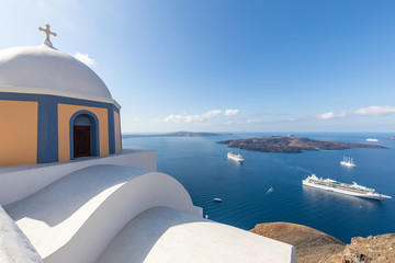 Church of Fira town at Santorini island, Greece. Summer travel landscape, amazing white architecture and cruise ships in blue sea
