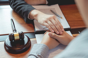 Lawyer working with client discussing contract papers with brass scale about legal legislation in courtroom, consulting to help their customer.