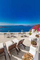 White chaise lounges on the terrace with sea view. White architecture on Santorini island, Greece.