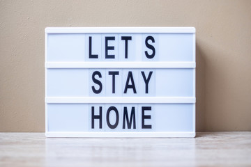lightbox with text LET S STAY HOME on table. Coronavirus, Covid-19, Quarantines and Social Distancing concept