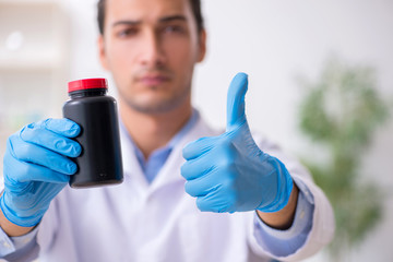 Young male lab assistant in drug synthesis concept