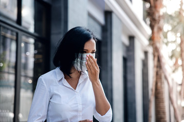 Covid-19 or Corona Virus or Air Pollution PM2.5 Situation Concept. Young Woman with Surgical Mask Coughing in Public Outdoor