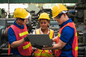 The industrial worker team is working on various projects in a large industrial factory with many...