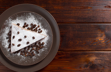 A piece of chocolate cake with sugar and coffee beans. Food, dessert, sweet. Biscuit, brownie, tiramisu, cheesecake. Cook at home. Bakery products.