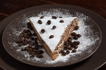 A piece of chocolate cake with sugar and coffee beans. Food, dessert, sweet. Biscuit, brownie, tiramisu, cheesecake. Cook at home. Bakery products.