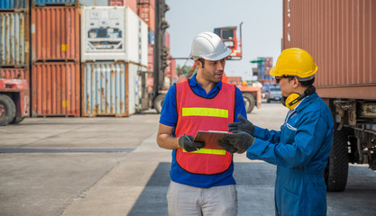 Foreman and dock worker staff working checking at Container cargo harbor holding clipboard. Business Logistics import export shipping concept.