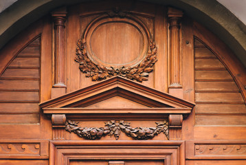 Antique luxury wooden door surrounded by handmade decor and carvings. Mahogany, portal to an ancient building. Oak leaf vignette, copy space, mockup.