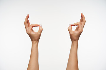Indoor photo of young lady's hands with white manicure forming murda gesture while posing over white background. Women showing hand with sign language