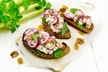 Bruschetta with fish and curd on wooden board