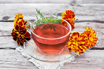 Tea herbal of marigolds in cup on board