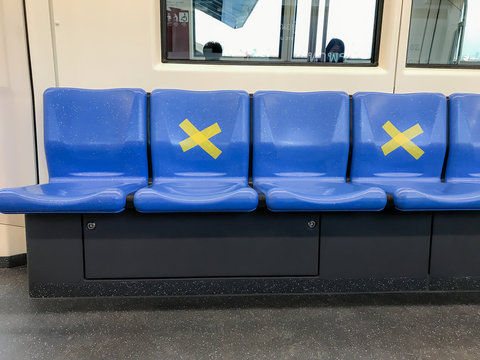 BANGKOK/THAILAND-Mar 29, 2020: Measure against COVID-19.Social distancing inside a MRT subway train. Yellow cross symbol on a seat means one shall not sit there.Infection control.