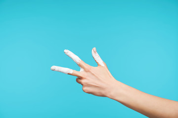 Horizontal shot of painted lady's hand being raised while showing figure three in body language or...