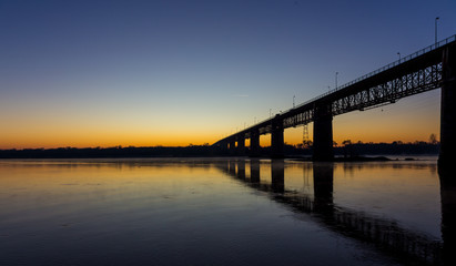 Fototapeta na wymiar Sunrise near a river and a bridge in Portugal