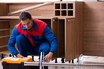Young handsome male carpenter working indoors