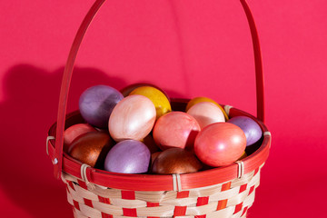 Easter eggs in basket isolated on red