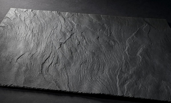 Black Matte Slate Natural Stone Plate With Textured Surface On Gray Background