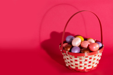 Easter eggs in basket isolated on red