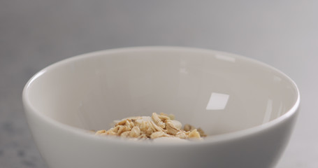 closeup granola with almond flakes in white bowl